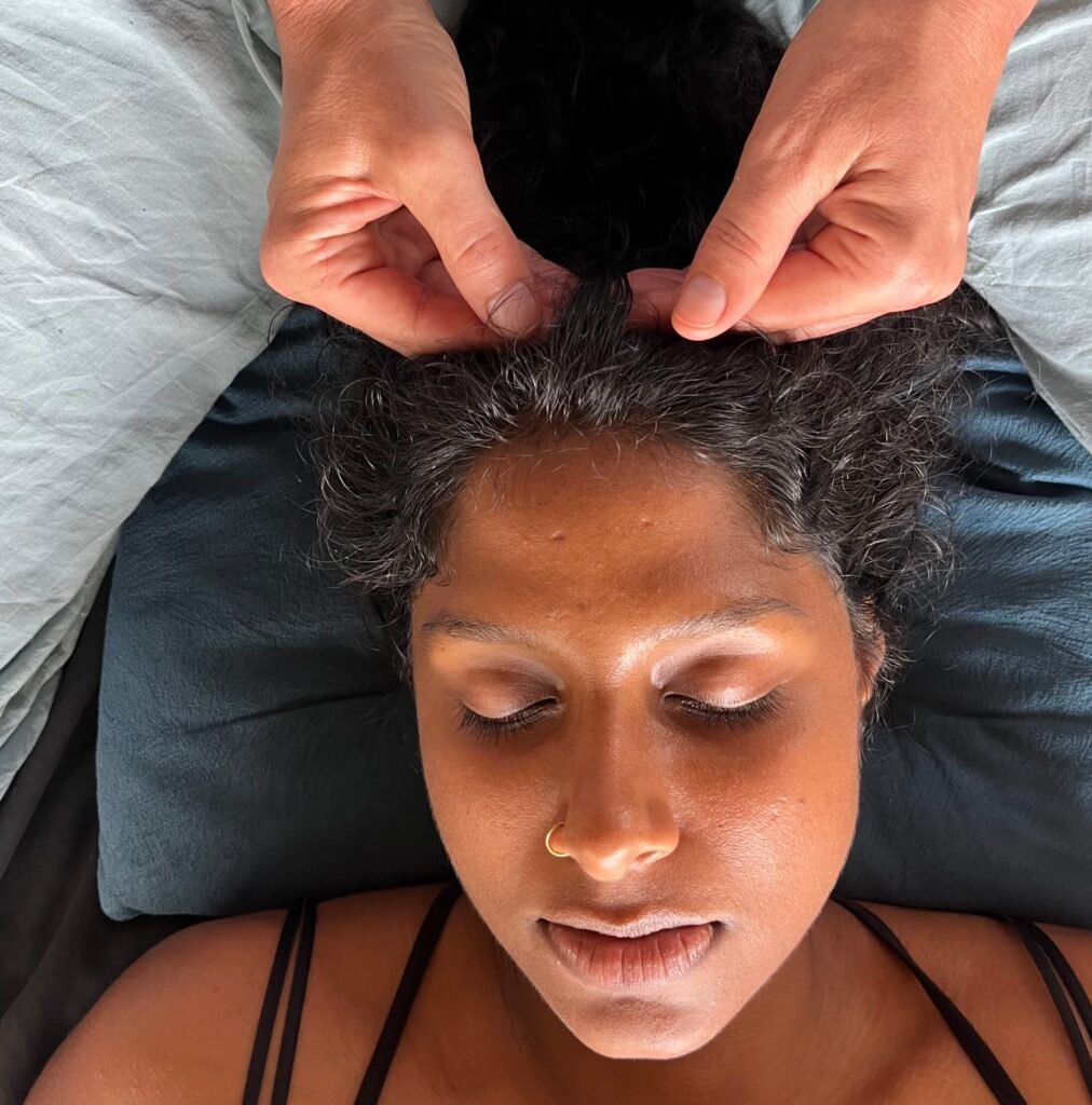 Access Bars energy healing session with hands on the pot of the head to release mental tension.